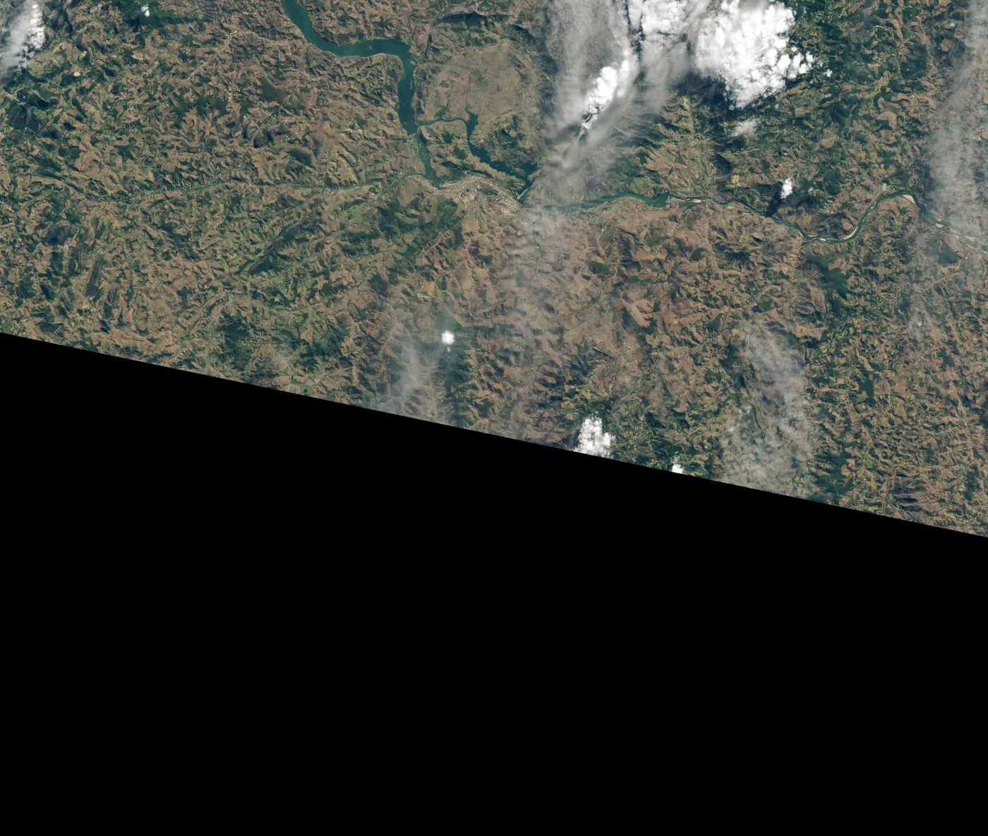 Landsat 8 satellite image from July 2019 showing a narrow dark green strip of new forest southwest of Aimorés, Brazil.