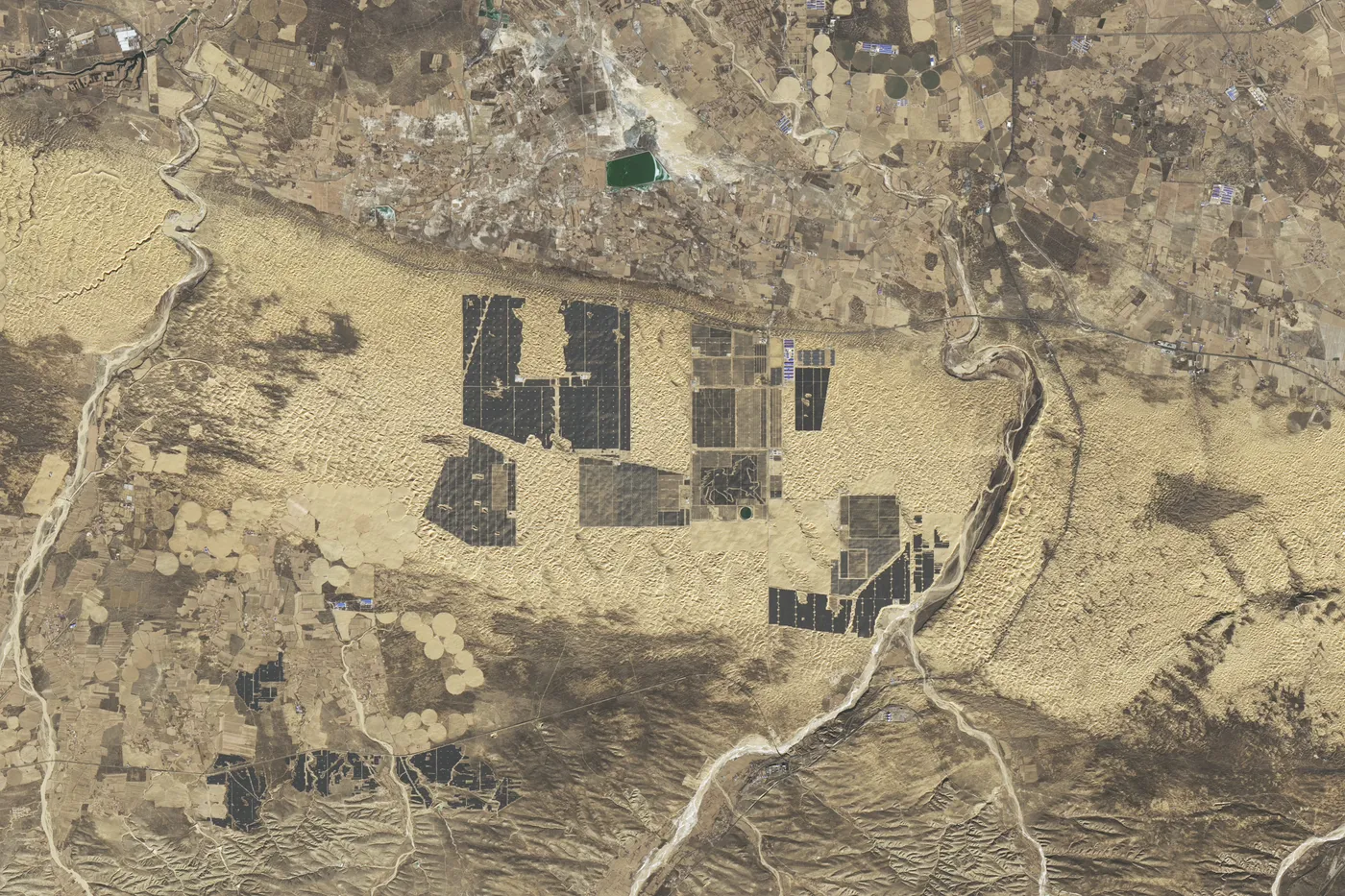 Landsat 9 image from December 2024 of the same area of the Kubuqi Desert, now covered by large solar panel arrays.